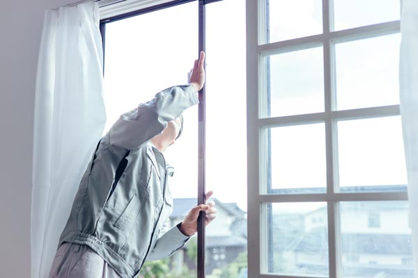 Homme remplaçant une vitre